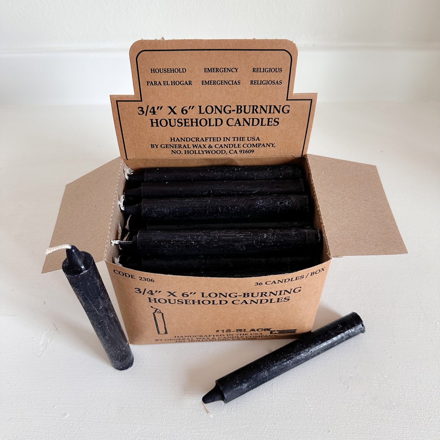 Box of black household candles with a cardboard box