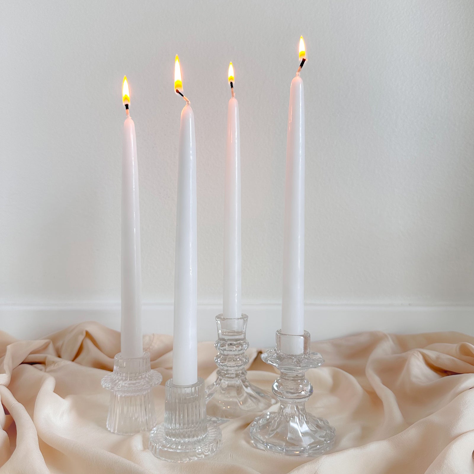 Four white candles in glass holders