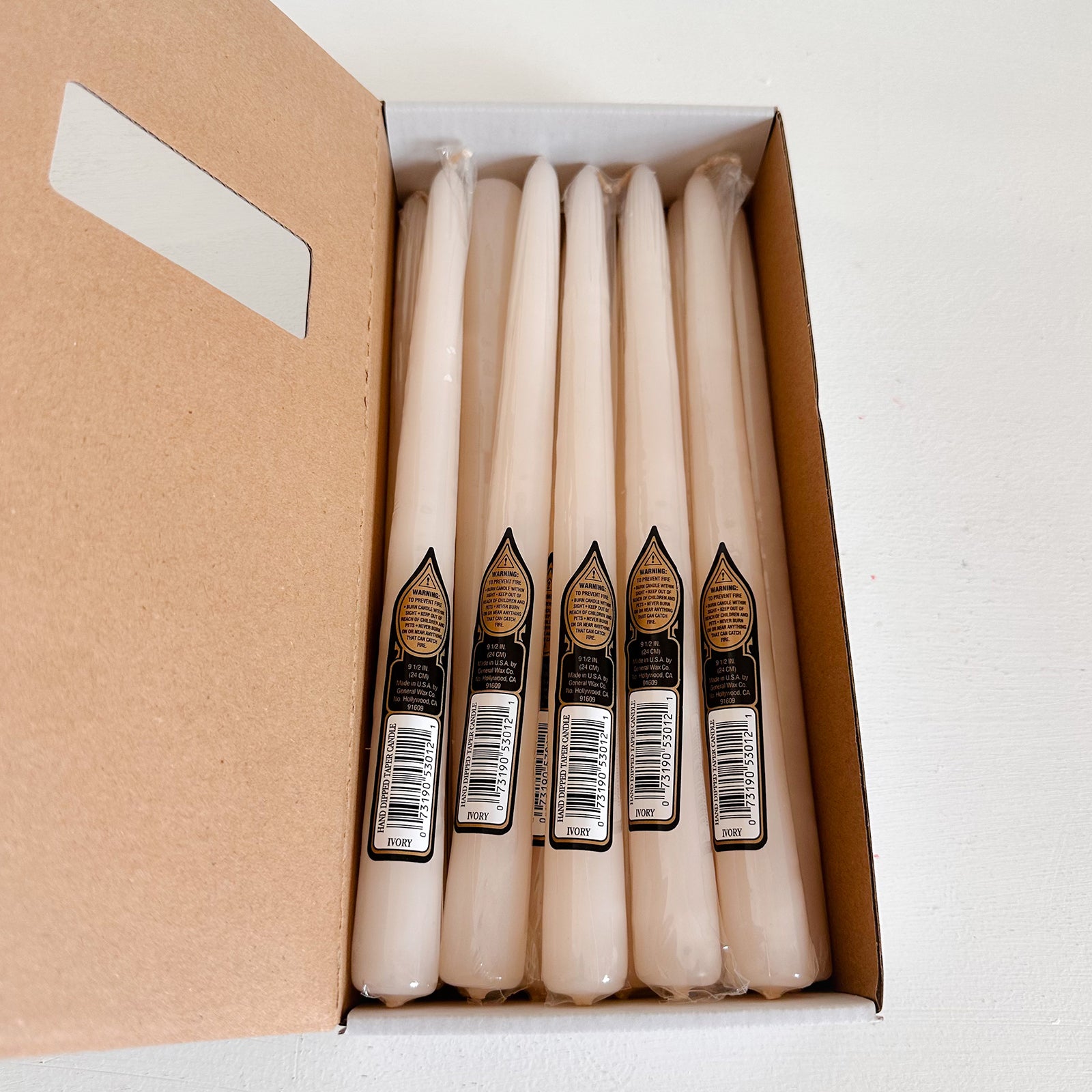 Box of six ivory candles with labels