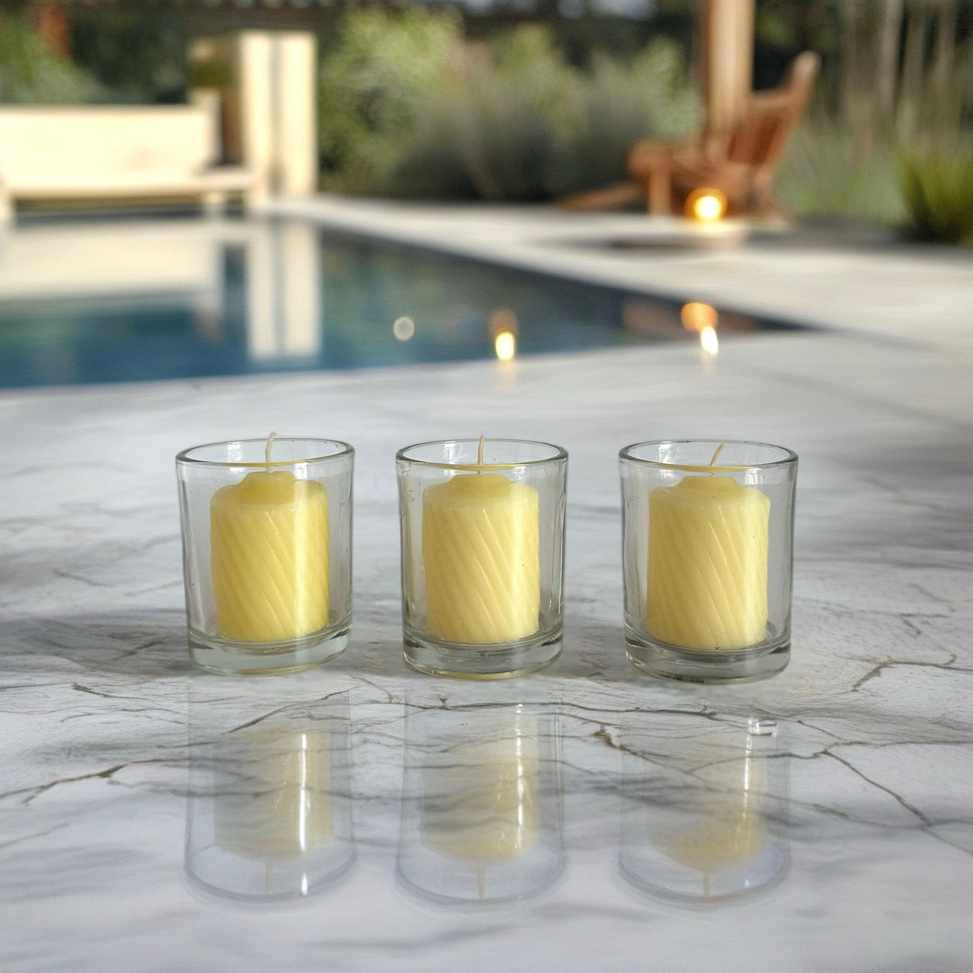 Three yellow candles in glass holders