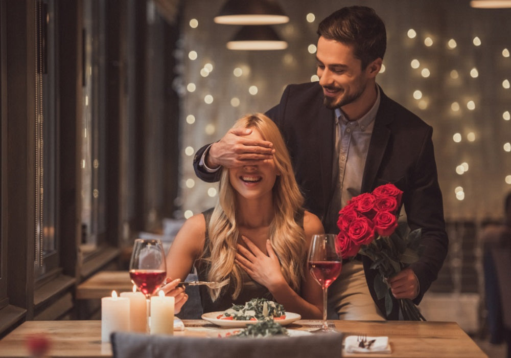 romantic Valentines Day dinner with white pillar candles and red roses